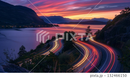 As the sun sets on the horizon the roads along the lake become a canvas for swirling car light trails 132466150