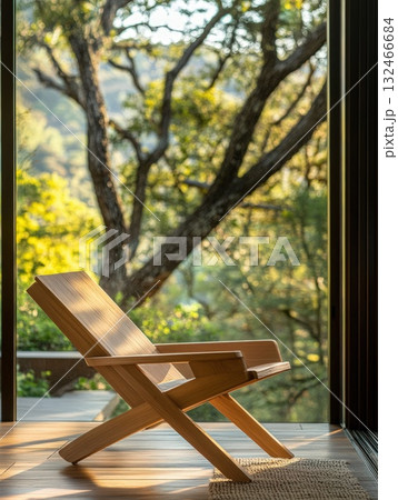 Rustic Wooden Chair with Natural Light and Lush Green Landscape View 132466684