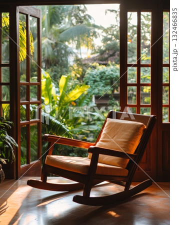 Wooden Rocking Chair on Sunlit Porch Overlooking Lush Tropical Garden 132466835