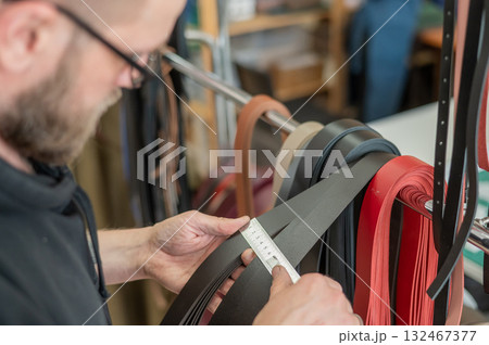 Caucasian bearded man working as a tanner in a workshop.  132467377