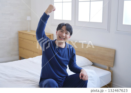 ベッドに座る20代男性 ガッツポーズ ベッドに座る20代男性 ガッツポーズ 132467623