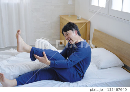 ベッドで足がつる20代男性 ベッドで足がつる20代男性 132467640