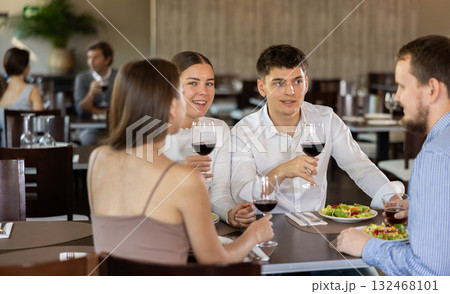 Couples of women and men eating and talking in restaurant Couples of women and men eating and talking in restaurant 132468101