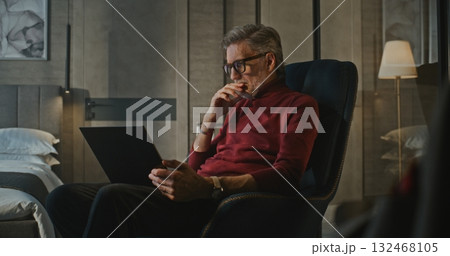 Elegant Businessman Uses Laptop in Stylish Hotel Interior 132468105