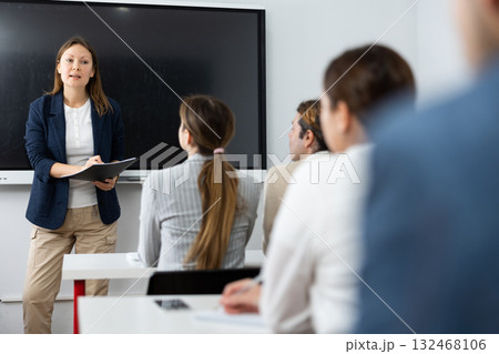Knowledgeable female professor explaining subject to classroom full of students 132468106
