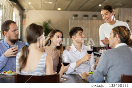 Female waitress taking order from group of friends in restaurant 132468151