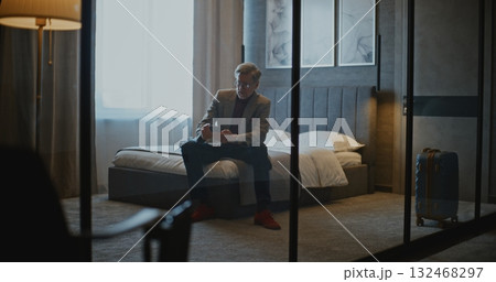 Sophisticated Gray Haired Businessman Arrives at Stylish Hotel Room Sophisticated Gray Haired Businessman Arrives at Stylish Hotel Room 132468297