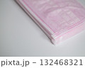 積み重ねられた淡いピンク色の不織布マスク 132468321