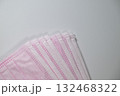 扇状に広がるピンク色の不織布マスクのクローズアップ 132468322