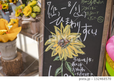 花屋の手書き看板とひまわりのイベント告知 132468570