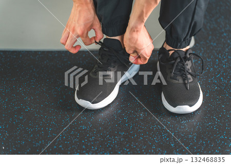 スポーツシューズ,スニーカーの紐を結ぶ男性の手元,足元 132468835