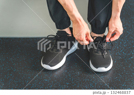 スポーツシューズ,スニーカーの紐を結ぶ男性の手元,足元 132468837