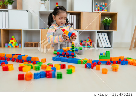 toddler girl playing building blocks or plastic bricks toy at home toddler girl playing building blocks or plastic bricks toy at home 132470212