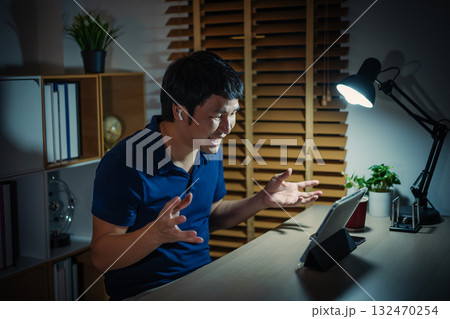 happy man using digital tablet and wireless earbuds making video call at night happy man using digital tablet and wireless earbuds making video call at night 132470254