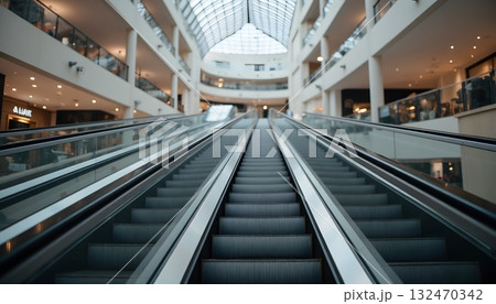 Modern Shopping Mall Interior with Escalators Leading to Upper Levels 132470342