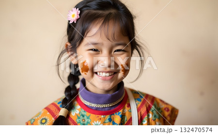 Smiling young girl wearing traditional colorful attire with floral patterns 132470574