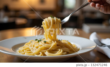 Delicious Plate of Spaghetti Twirled on Fork Ready for Tasting in Cozy Restaurant Setting Delicious Plate of Spaghetti Twirled on Fork Ready for Tasting in Cozy Restaurant Setting 132471246