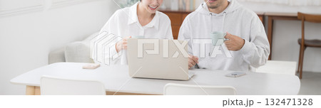 綺麗なリビングでダイニングパソコンを見ながら話す夫婦　幸せな結婚のイメージ	　バナー 132471328