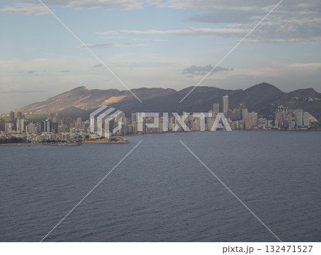 seaside cityscape view, peaceful coast scene featuring calm waters and mountainous horizon seaside cityscape view, peaceful coast scene featuring calm waters and mountainous horizon 132471527