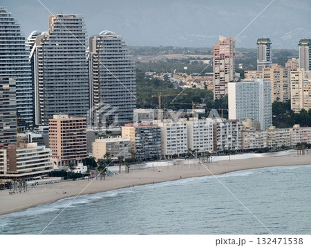 peaceful urban seaside scene during noon, quiet promenade along sunny beach with highrise residences 132471538
