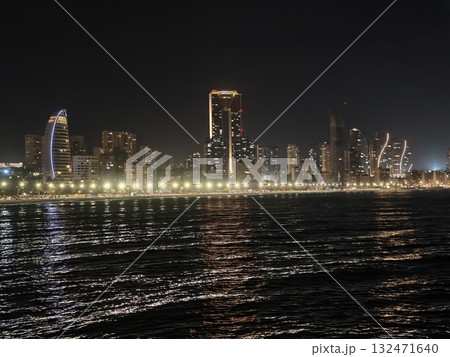 bright skyline silhouette, distinctive vertical shape dominates horizon with shimmering waterfront bright skyline silhouette, distinctive vertical shape dominates horizon with shimmering waterfront 132471640