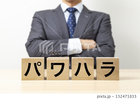 「パワハラ」と書かれたブロックと腕組みをするビジネスマン 132471833