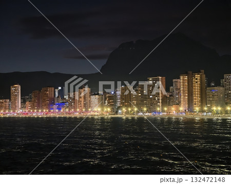 vivid night stroll, evening celebration featuring illuminated facades and shimmering water 132472148