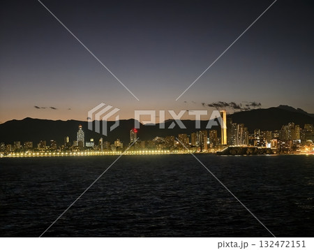 bright urban horizon view, serene city skyline illuminated by landmark tower and coastal reflections bright urban horizon view, serene city skyline illuminated by landmark tower and coastal reflections 132472151