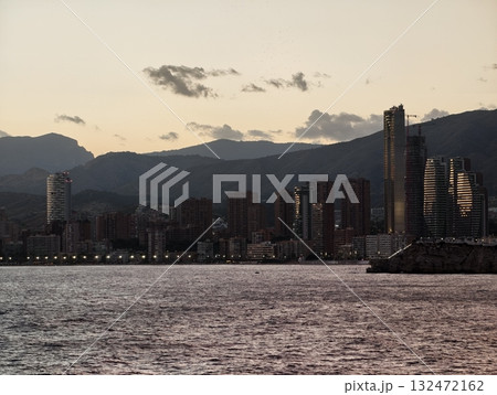 serene shoreline with distant peaks, calm coastal landscape with fading sunset and distant mountains serene shoreline with distant peaks, calm coastal landscape with fading sunset and distant mountains 132472162