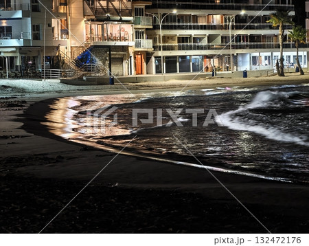 quiet city beach at night, serene nighttime seaside scene with shimmering reflections and calm waves quiet city beach at night, serene nighttime seaside scene with shimmering reflections and calm waves 132472176