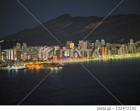 bright coastlines with distant mountains, sparkling shoreline lights beneath mountainous silhouette bright coastlines with distant mountains, sparkling shoreline lights beneath mountainous silhouette 132472192