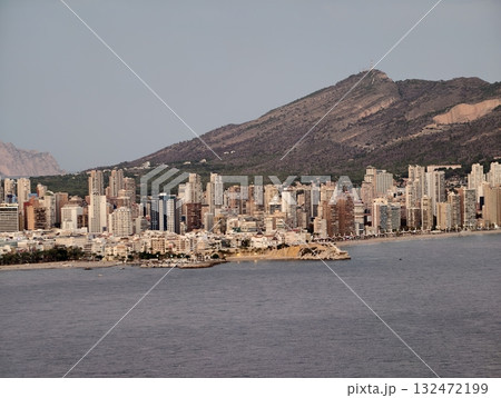 calm waterfront scene with distant hills, tranquil bay view featuring glowing towers and soft clouds calm waterfront scene with distant hills, tranquil bay view featuring glowing towers and soft clouds 132472199