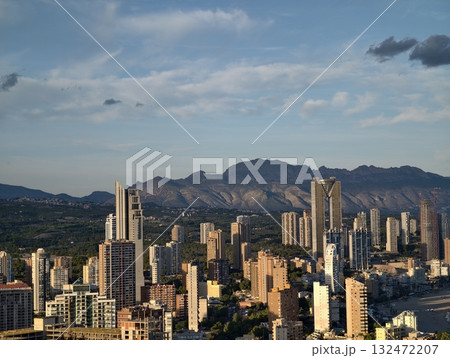 modern skyline near distant hills, vibrant city outline set against scenic mountain and hill 132472207