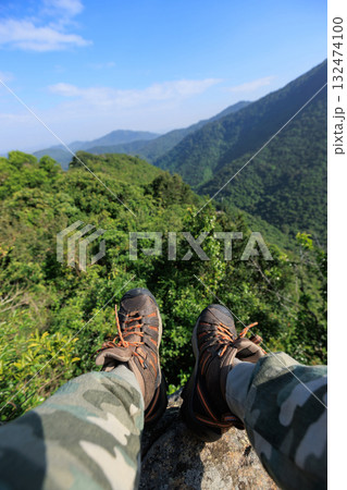 Successful hiker stand on sunrise mountain top cliff edge 132474100