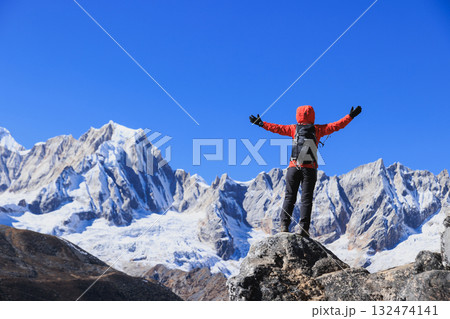 Backpacking woman hiking on high altitude mountain top Backpacking woman hiking on high altitude mountain top 132474141
