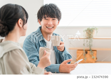 ダイニングテーブルでホットドリンクを飲みながら会話するカップル,夫婦 ダイニングテーブルでホットドリンクを飲みながら会話するカップル,夫婦 132474390