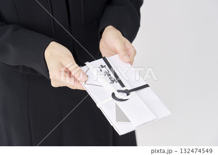 香典を渡す喪服を着た女性 白背景 顔無し 香典を渡す喪服を着た女性 白背景 顔無し 132474549