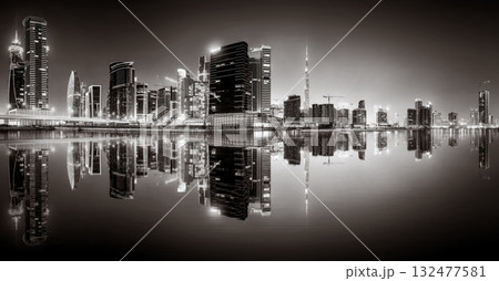 Urban city skyline with illuminated skyscrapers and waterfront railing in black and white at night, Dubai Marina bay UAE Urban city skyline with illuminated skyscrapers and waterfront railing in black and white at night, Dubai Marina bay UAE 132477581