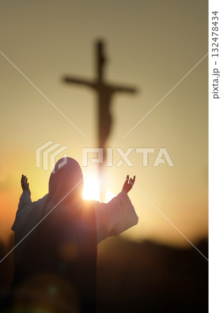 Christian silhouettes raising their hands toward the cross of Jesus Christ, praying in sorrow, Holy Week background 132478434