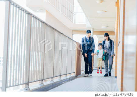 平日の朝に家族で家を出る 132479439