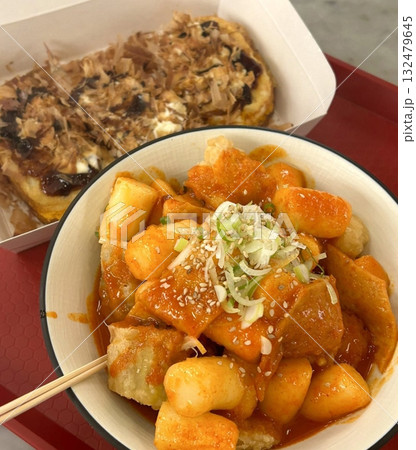 Chewy and spicy tteokbokki served with savory takoyaki balls, offering a delicious fusion of Korean and Japanese street food flavors in one delightful meal. Chewy and spicy tteokbokki served with savory takoyaki balls, offering a delicious fusion of Korean and Japanese street food flavors in one delightful meal. 132479645