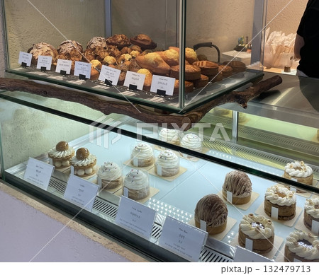 Beautiful and delicious pastries displayed in a bakery, with colorful glazes, delicate toppings, and tempting textures—offering a perfect visual feast of sweetness and artisanal charm. 132479713