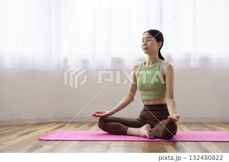 ヨガマットの上で瞑想する女性 132480822