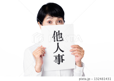 他人事と書かれた紙を持ちこちらへ視線を送る白いシャツを着たシニア女性 他人事と書かれた紙を持ちこちらへ視線を送る白いシャツを着たシニア女性 132481431