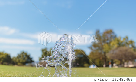 青空と公園を背景に光り輝く水の滴る水滴 青空と公園を背景に光り輝く水の滴る水滴 132481465
