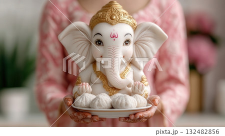 A Beautifully Crafted Idol of Ganesha Held by a Devotee, Symbolizing Prosperity, Wisdom A Beautifully Crafted Idol of Ganesha Held by a Devotee, Symbolizing Prosperity, Wisdom 132482856