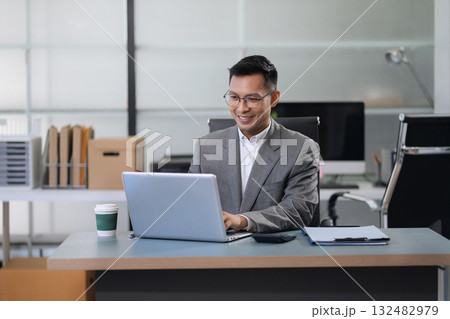 Businessman using laptop computer in office. 132482979