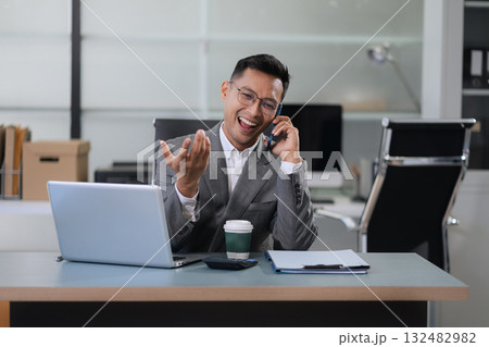 Businessman using laptop computer in office. Happy man, entrepreneur, small business owner working online. Businessman using laptop computer in office. Happy man, entrepreneur, small business owner working online. 132482982