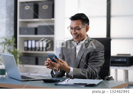 Happy young male use laptop feel euphoric overjoyed triumph with good news over smartphone call. Happy young male use laptop feel euphoric overjoyed triumph with good news over smartphone call. 132482991