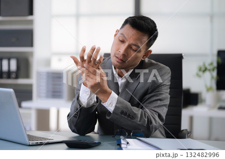 Male businessman is doing a stretchy posture due to sitting in the office for too long, office syndrome concept. Male businessman is doing a stretchy posture due to sitting in the office for too long, office syndrome concept. 132482996